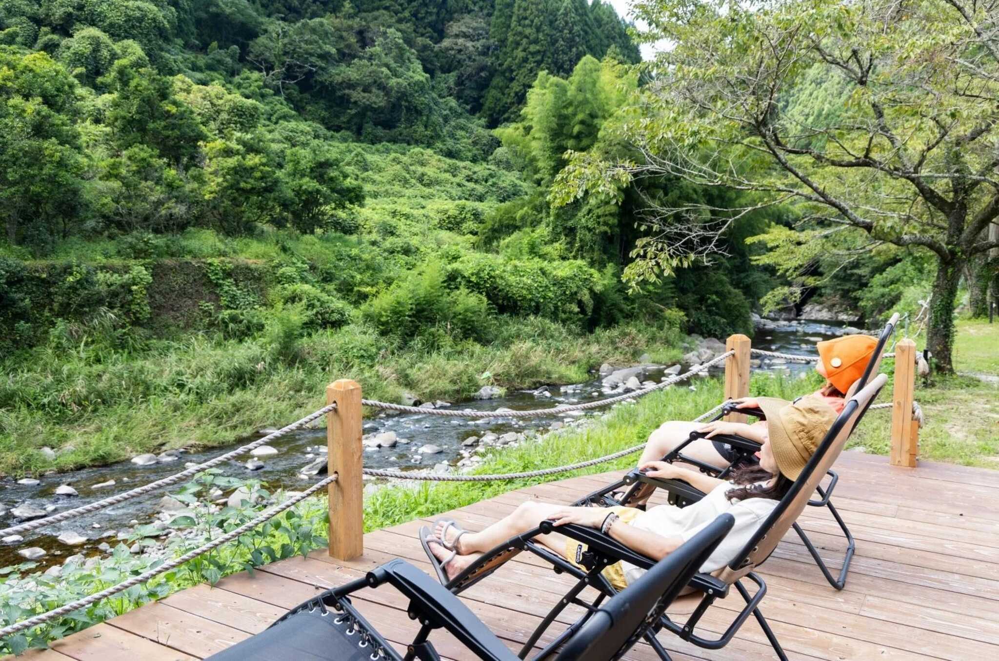 川沿いウッドデッキに整い椅子を設置。川のせせらぎと鳥の声を聞きながら外気浴ができます。