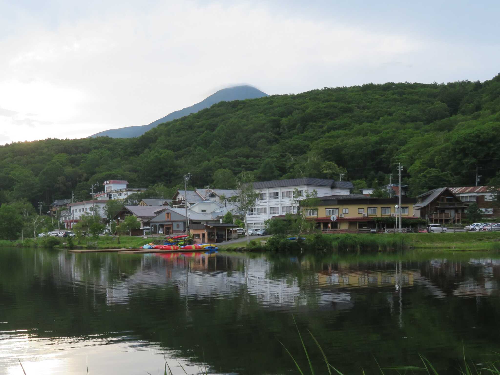 3階建ての白いビルの左側にある路地の奥がキャンプ場