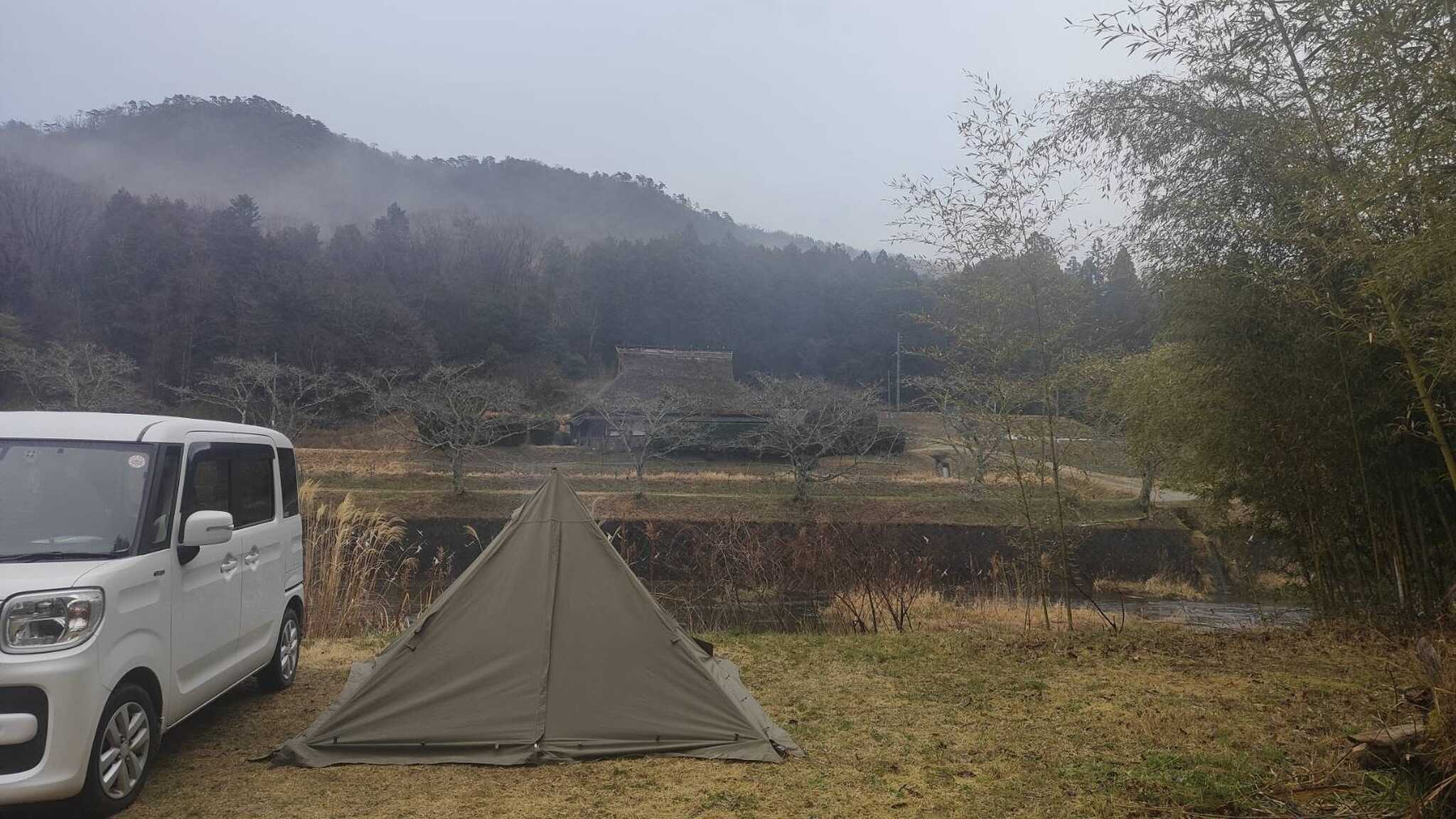 目の前に茅葺きの家と川