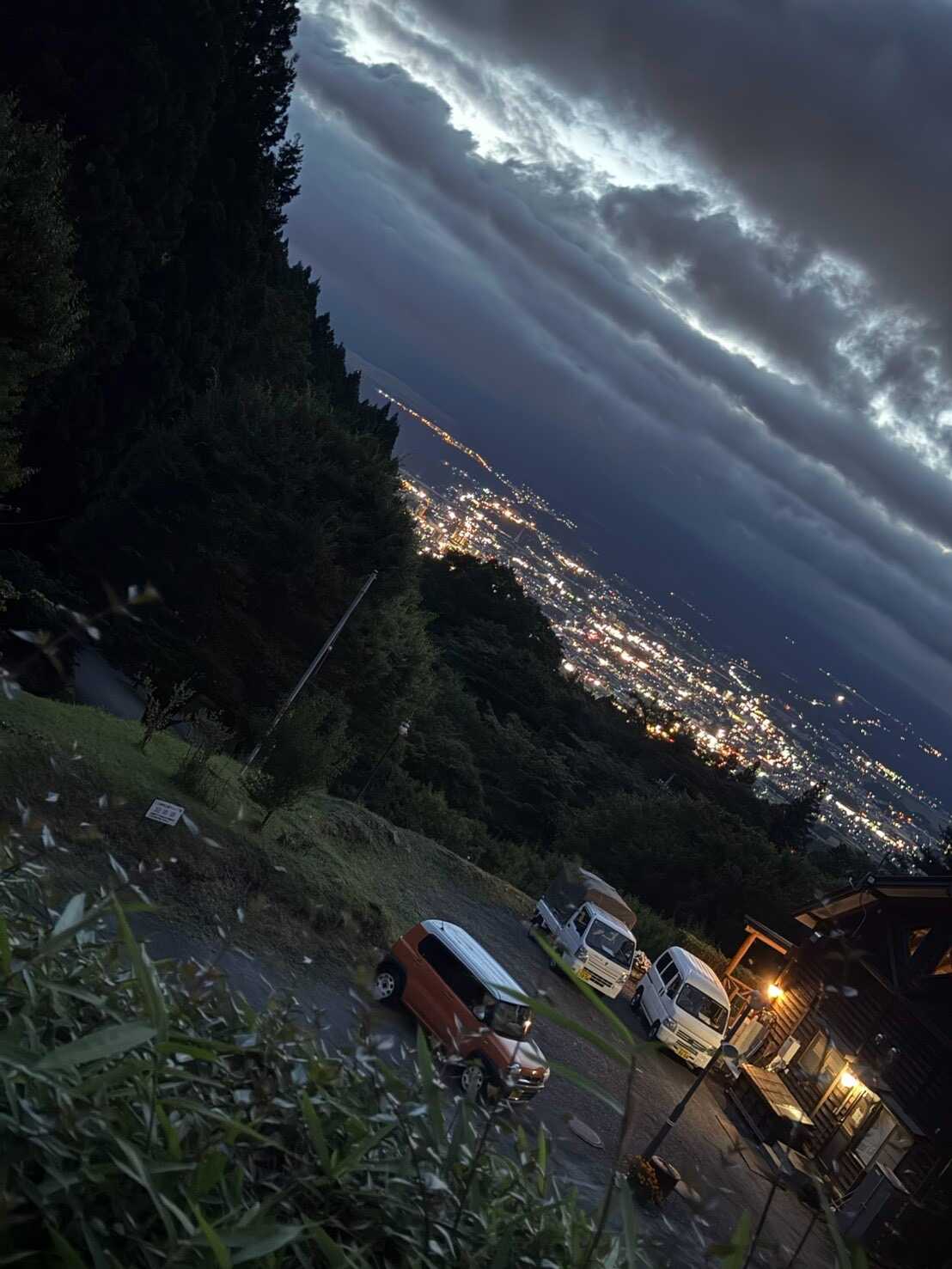 サイトから夜景と雲に隠れた富士山