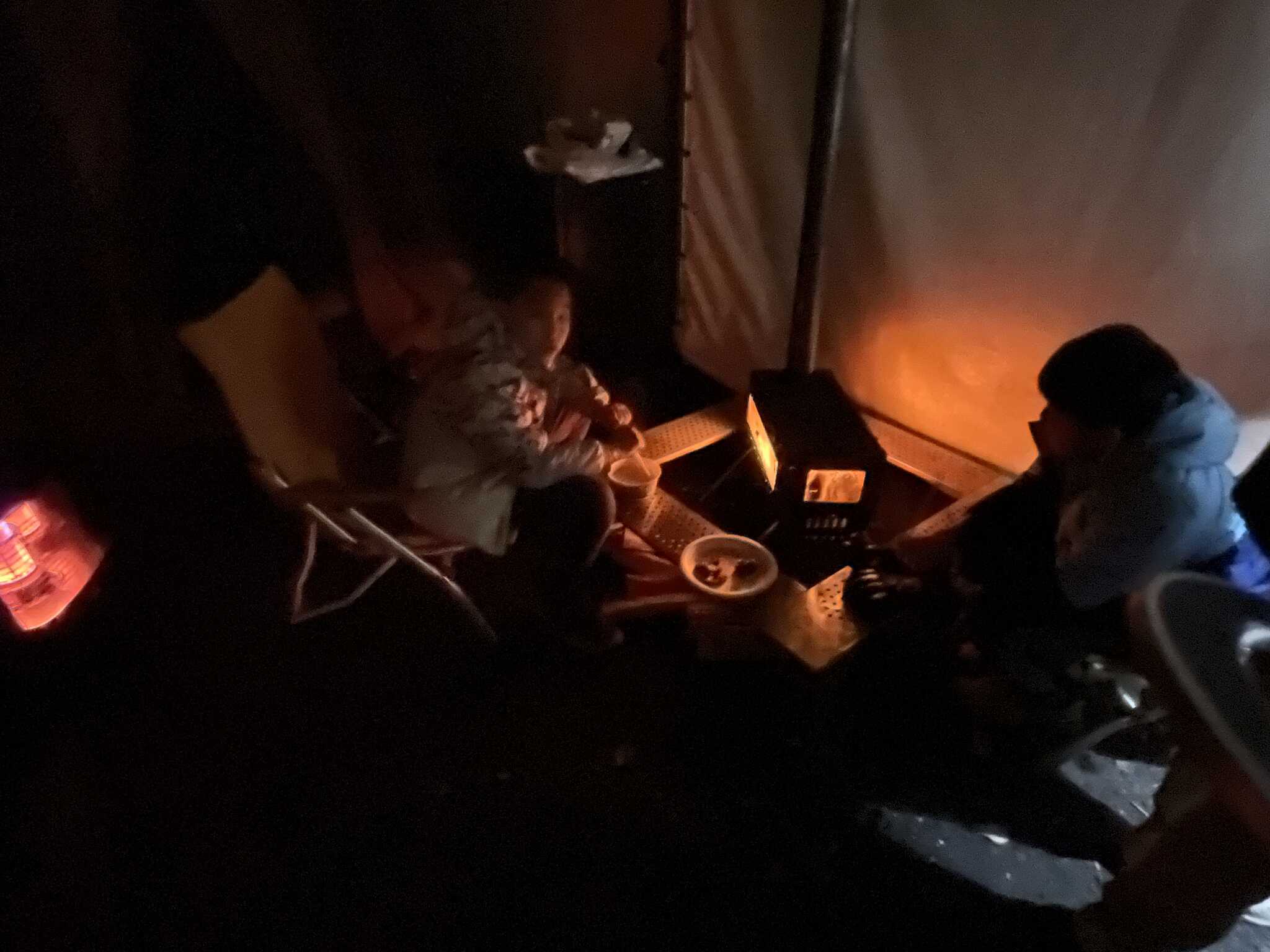 全家圍著柴爐度過雪地露營的夜晚